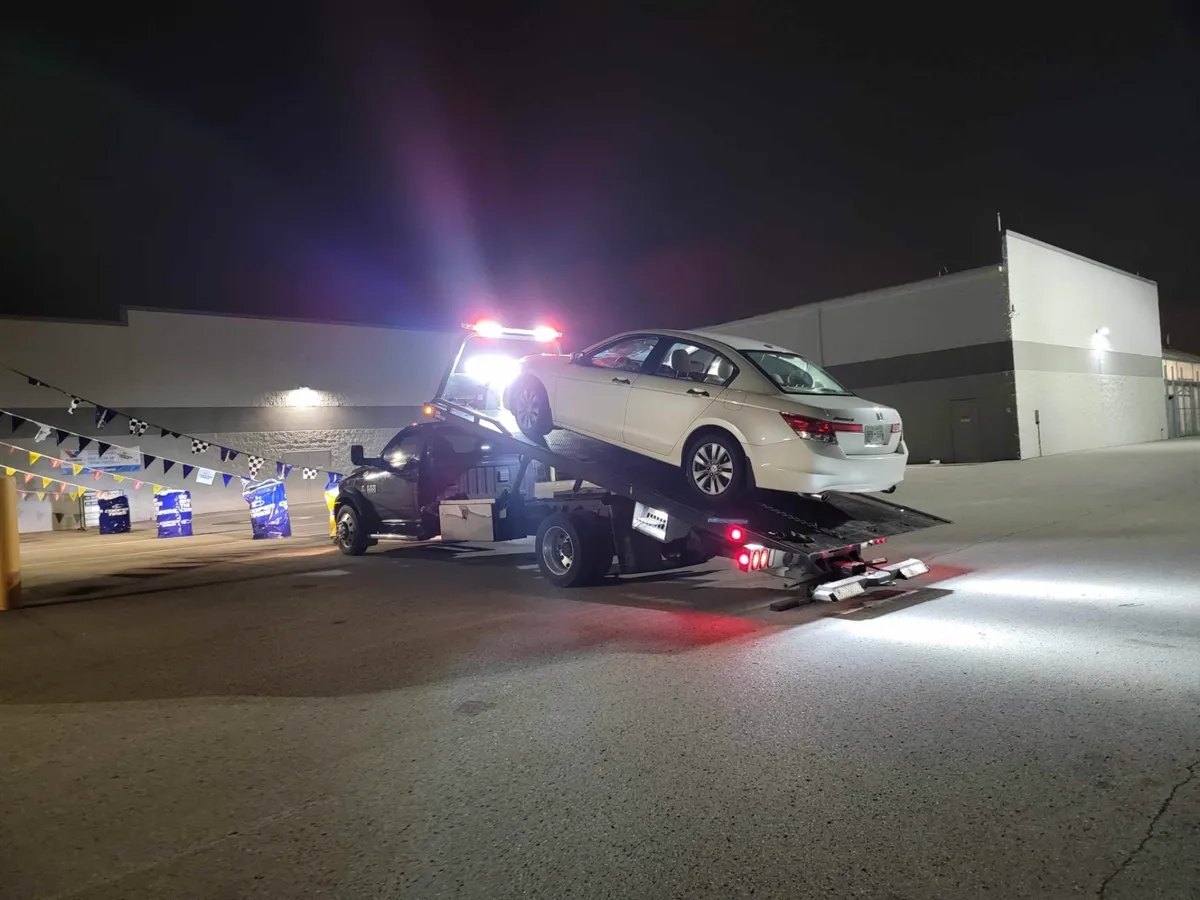 Hook Em' Up Towing truck loading a car at night in Nashville