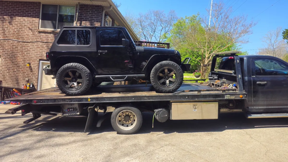 Jeep strapped down on a Hook Em' Up Towing flatbed in Nashville